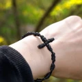 Bransoletka z krzyżykiem - Dziesiątek różańca na rękę z materiału - czarny (jednostronny ściągacz) - na ręce