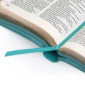 Złocone kartki w biblii turkusowej.